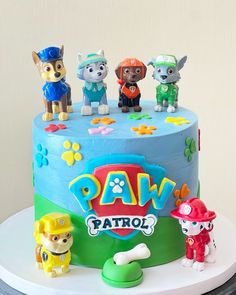 a birthday cake decorated with dogs and paw patrol figurines on top of it