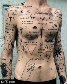 a man with many tattoos on his body and chest is standing in front of a wall