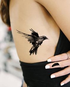 a woman's stomach with a bird tattoo on it