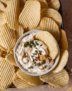 a bowl of dip surrounded by chips