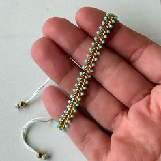 a person holding a beaded bracelet in their hand