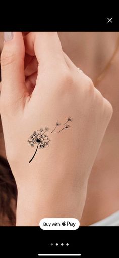 a woman's wrist with a dandelion tattoo on the left side of her arm