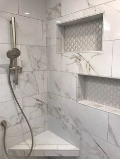 a bathroom with white marble walls and flooring, including a walk - in shower