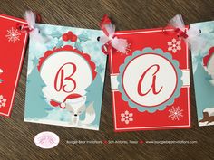 three red and blue christmas cards with the letter b hanging from it's sides