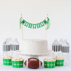 a cake, cupcakes and football on a table