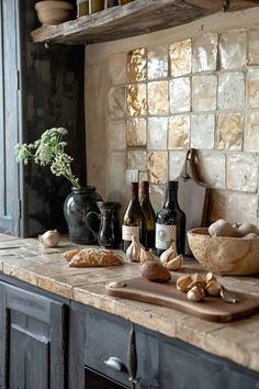 a kitchen counter with wine bottles, bread and other food items on top of it