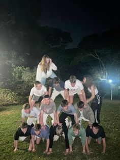 a group of people are posing for a photo in the grass with their hands on their hipss