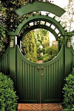 a green gate with a circular mirror in the middle