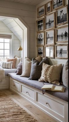 a window seat with lots of pillows and pictures on the wall in front of it