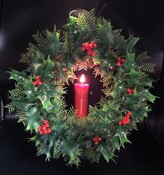 a candle is lit in the center of a wreath