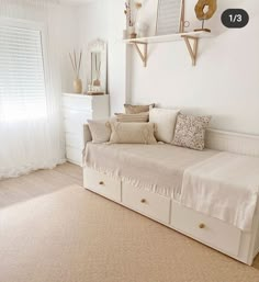 a living room with a white couch and two shelves on the wall next to it