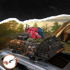 a car with luggage strapped to the roof in front of a tent and camping site