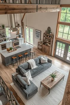 a living room filled with furniture next to a kitchen and an open concept floor plan