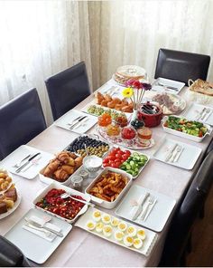 a table filled with lots of food sitting on top of a white tablecloth covered table