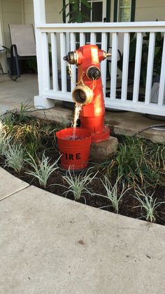 an orange fire hydrant with water coming out of it's mouth in front of a house