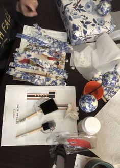 an assortment of items on a table including paint, brushes and other crafting supplies