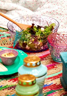 a table topped with plates and bowls filled with food next to a bowl of salad