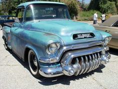 an old blue truck parked next to another car