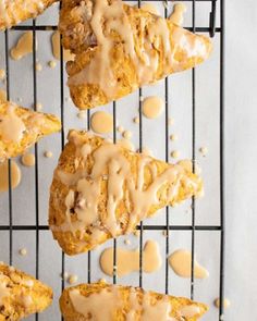 several scones with icing sitting on a cooling rack