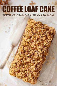 coffee loaf cake with cinnamon and cardamom frosting on a white plate next to a spoon