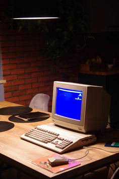 a desktop computer sitting on top of a wooden desk next to a keyboard and mouse