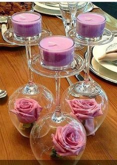 three wine glasses with candles in them sitting on a table