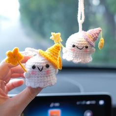 two crocheted stuffed animals hanging from a car dashboard