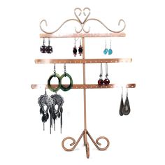 a jewelry rack with several pairs of earrings hanging from it's sides and two hooks on each side