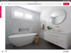 a white bath tub sitting next to a sink in a bathroom under a round mirror