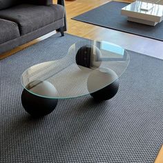 a modern glass table in the middle of a living room