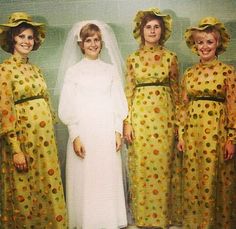 four women dressed in yellow dresses and hats posing for a photo with one woman wearing a white dress