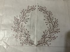 a piece of paper that has some type of embroidery on it and is sitting on top of a table