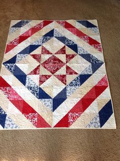 a red, white and blue quilt on the floor