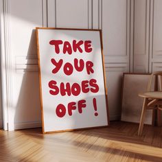 a sign that says take your shoes off on the floor next to a wooden chair