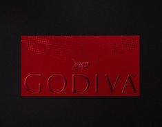 the word godiva written in red on a black background with an embossing effect