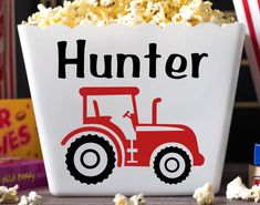 a bucket filled with popcorn sitting on top of a table next to boxes of popcorn