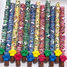 many colorful candles are lined up on a white plate with confetti and sprinkles