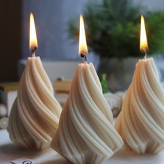 three white candles sitting on top of a table