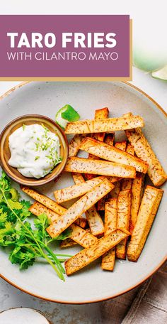 a plate filled with taco fries next to a bowl of sour cream and lettuce