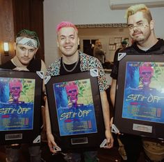 three men holding up framed posters in front of their faces and the words set it off on them