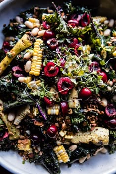 a white plate topped with salad and corn