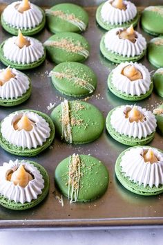 green and white decorated cookies sitting on top of a pan