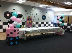 a party room decorated with balloons and streamers in the shape of polka dotes