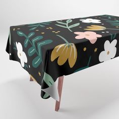 an image of a table cloth with flowers and leaves on black background, that is also available in multiple colors