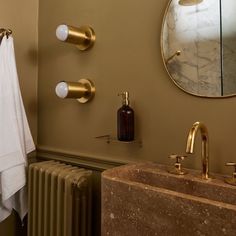 a bathroom with gold fixtures and marble sink