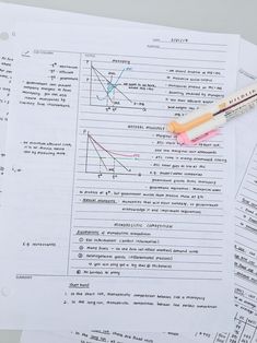 a pen and calculator sitting on top of some paper with graphs in it