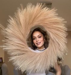 a woman is posing for a photo while wearing a large furry thing around her neck