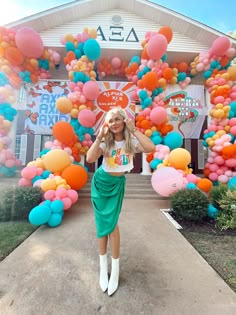 a woman standing in front of a building with balloons