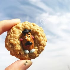 a hand holding a cookie with a cartoon character on it