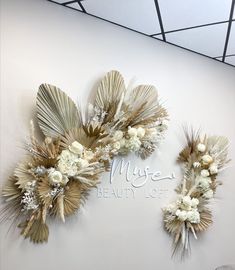 the wall is decorated with white flowers and gold leaf decorations on it's sides